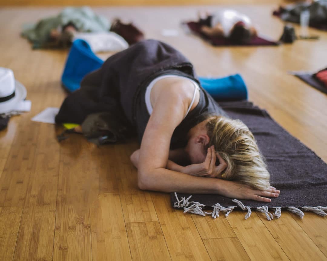 Woman lying on the floor doing breathwork in a class with Jon Paul Crimi - breathe with Jon Paul Crimi